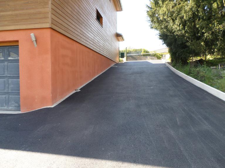 A gauche de la photo, bordure en pavés pour "donner" le niveau de l'enrobé contre la maison, à droite, bordure haute pour retenir la terre de la propriété voisine. 