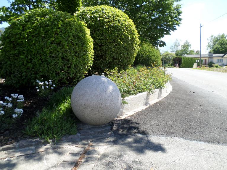 Bordure haute et sphère décorative en pierre pour marquer l'accès. Bordure haute et sphère décorative en pierre pour marquer l'accès.